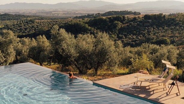 A swimming pool with clear water, surrounded by olive trees and a view of distant mountains. - Stargazer – Your Sky‑View Hideaway in the Tuscan Hills (Toskana)