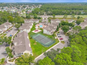 Ein Luftbild eines Wohngebiets mit Häusern, einem Tennisplatz und einem Schwimmbecken.