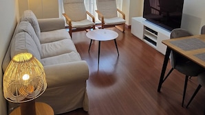 A living room with a sofa, two armchairs, a coffee table, a TV, and a lamp. - Ola Rosaleda (Málaga)