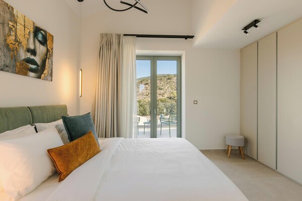 A modern bedroom with a large bed, a view of the outdoors, and a painting on the wall.