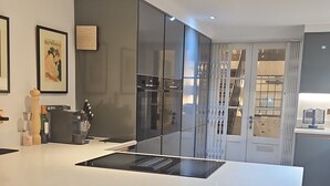 Una cocina moderna con una isla grande, taburetes de bar y un horno empotrado.