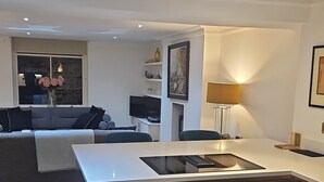 Una cocina moderna con una isla central, electrodomésticos integrados y una zona de comedor con sofá.
