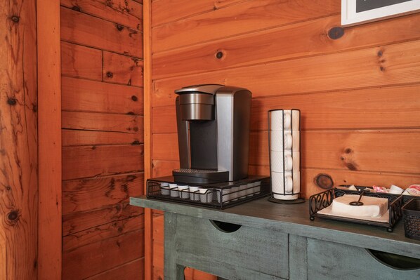 A wooden wall with a modern coffee maker and a white candle holder on a table. - Ridgeview Retreat | Hocking Hills, Hot Tub, Sauna (South Bloomingville)