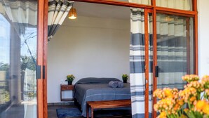 Un dormitorio con cama, mesitas de noche y un banco.
