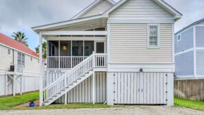 A two-story house with a covered porch and a staircase leading to the second floor. - Bay Breeze - 3 Min Walk to Beach (Tybee Island)