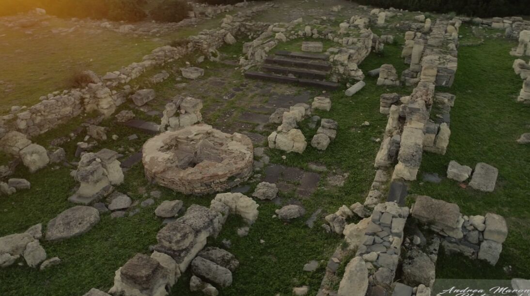 Un sitio arqueológico con ruinas de piedra y una estructura circular de piedra.