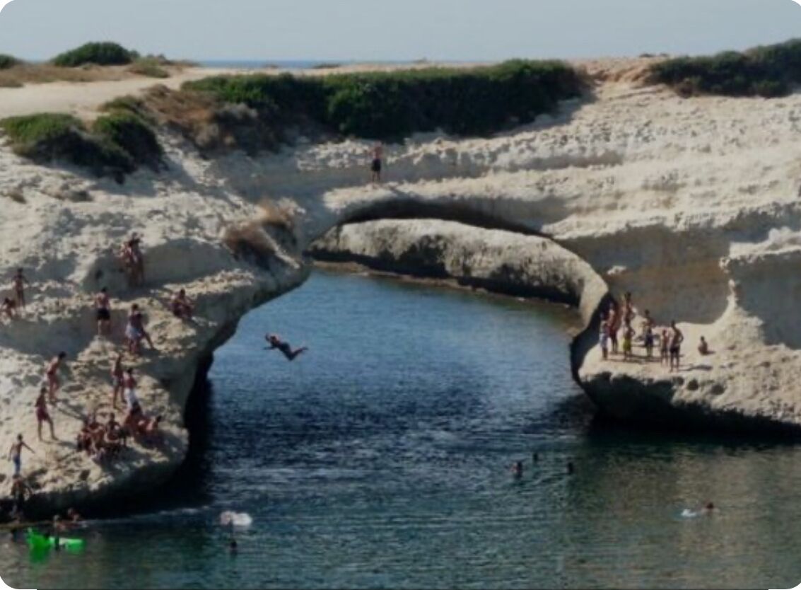 A beach with a natural rock formation creating a water channel.