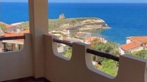 Un balcon avec vue sur la mer et une île rocheuse.