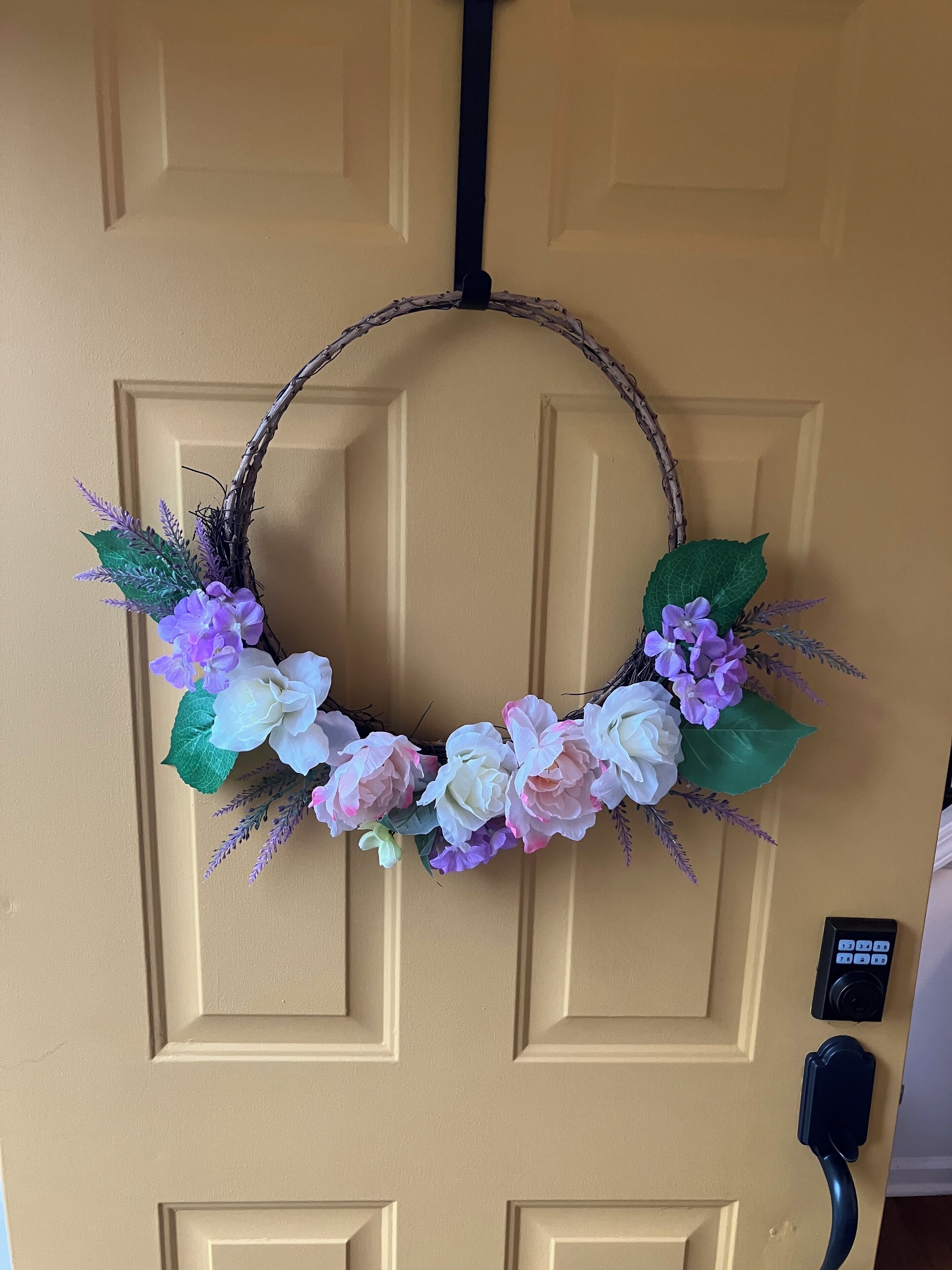 A door with a wreath made of branches and flowers.