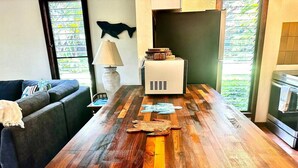 Eine moderne Küche mit einer Holztheke, einem Essbereich mit einer Couch und Blick auf Grünflächen.