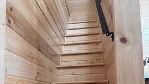A wooden staircase with a handrail, leading to a higher level. - Cozy 2-bedroom cabin # 101 (Moab)