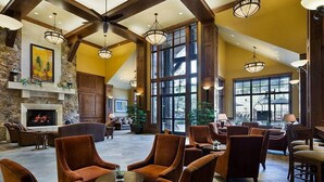A spacious lobby with a fireplace, comfortable seating, large windows, and a stone accent wall. - Exquisite ski-in, ski-out! 1 or 2-bedroom condo on Peak 7 in Breckenridge! (Breckenridge)