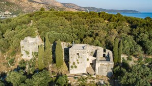 An ancient stone structure surrounded by dense forest and hills. - Bayside House in Corfu (Corfu)