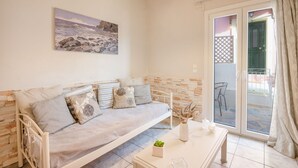 A modern living room with a sofa, a coffee table, and a painting on the wall. - Bayside House in Corfu (Corfu)