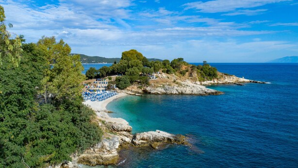 A coastal beach with clear blue waters, rocky terrain, and lush greenery. - Bayside House in Corfu (Corfu)