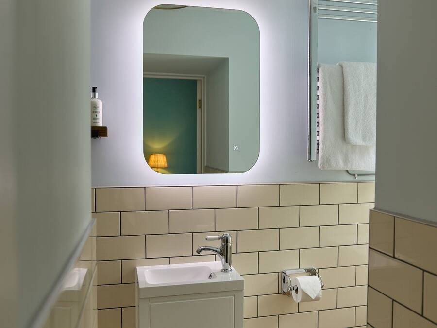 A bathroom with a sink, mirror, and towel rack.
