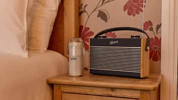 A bedside table with a radio and a glass of water.