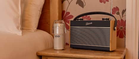 Una mesita de noche con una radio y un vaso de agua.