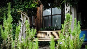 A wooden bench in a garden with a stone pathway, surrounded by greenery and a wooden fence. - 40 Acre Estate, Beach Access, Horses, Sleeps up to 6 on Vashon Island (Vashon)