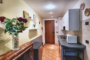 Cocina compacta con horno integrado, microondas y estufa.