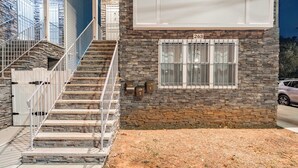 A two-story building with a stone facade, a set of stairs with metal railings, and a mailbox labeled '263'. - Comfy Unit Loft 15 min to EWR (Newark)