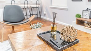 A modern living room with a wooden coffee table, a decorative sphere, and a remote control. - Comfy Unit Loft 15 min to EWR (Newark)