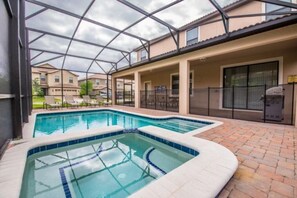 Relax by the pool surrounded by lounge chairs and a patio area.