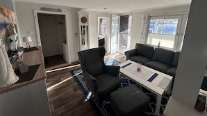 A modern interior with a dining area, a sofa, and a kitchen counter. - NEW! Vacation home Nordlicht (Südbrookmerland)