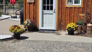 A wooden building with a white door and window, a sign reading "Bunk Board", and potted plants in front. - Sheltered Nook Bunk 'n Board
Farm to Table experience  (Molt)