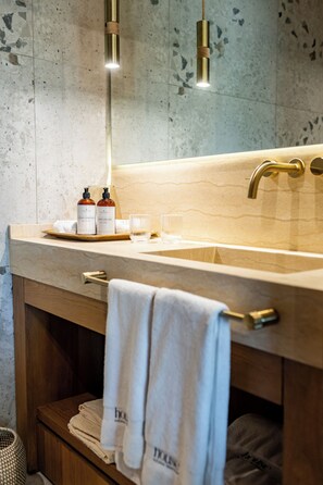 Ein modernes Badezimmer mit einem großen Waschbecken, einem Holzwaschtisch und einem Handtuchhalter.