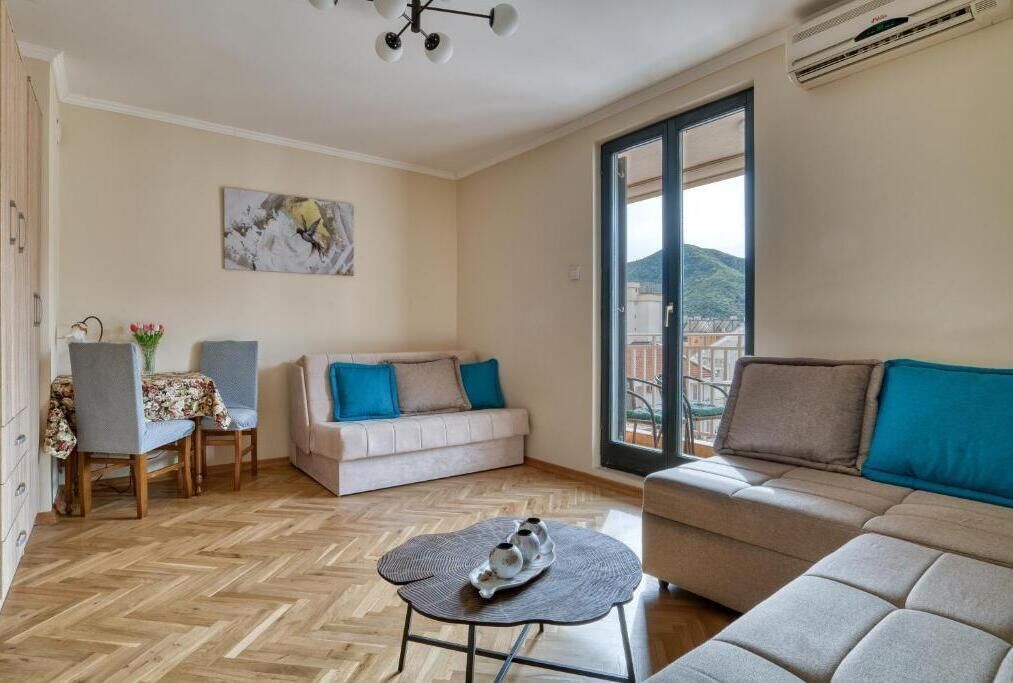 Un salon comprenant un canapé, une table basse, une table à manger avec des chaises et un tableau accroché au mur.