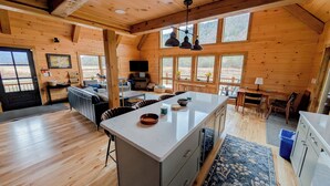 Een ruime hut met een grote keuken, een eethoek en een gezellige woonkamer.