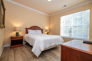 Cozy retreat with a large bed, nightstands, and a desk.