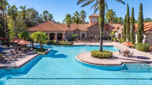 Relax by the pool surrounded by lush greenery and lounge chairs.