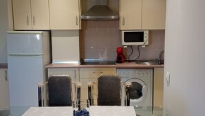 Cuina compacta amb frigorífic, microones i rentadora.