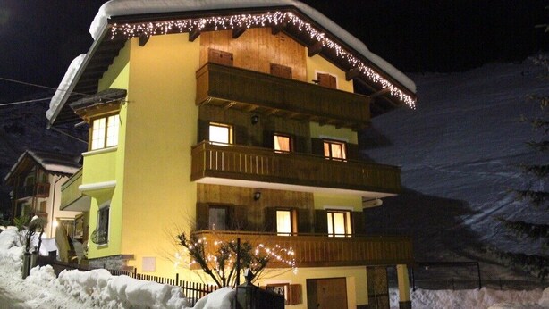 Un edificio de varios pisos con balcones, rodeado de nieve.