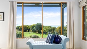Ein Zimmer mit einem großen Fenster und Blick auf eine grüne Landschaft und Bäume.
