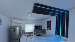A modern kitchen with a built-in microwave, a stainless steel refrigerator, and a sink.