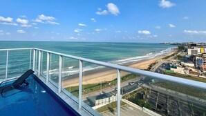 Ein Balkon mit Blick auf Strand und Meer.