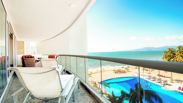 Un balcone con vista sulla spiaggia e sulla piscina.