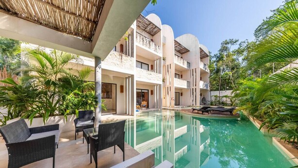 A hotel with a swimming pool, outdoor seating, and lush greenery. - Lux 1 BR w/ Pool in Tulum Jungle @ Paraiso (Tulum)