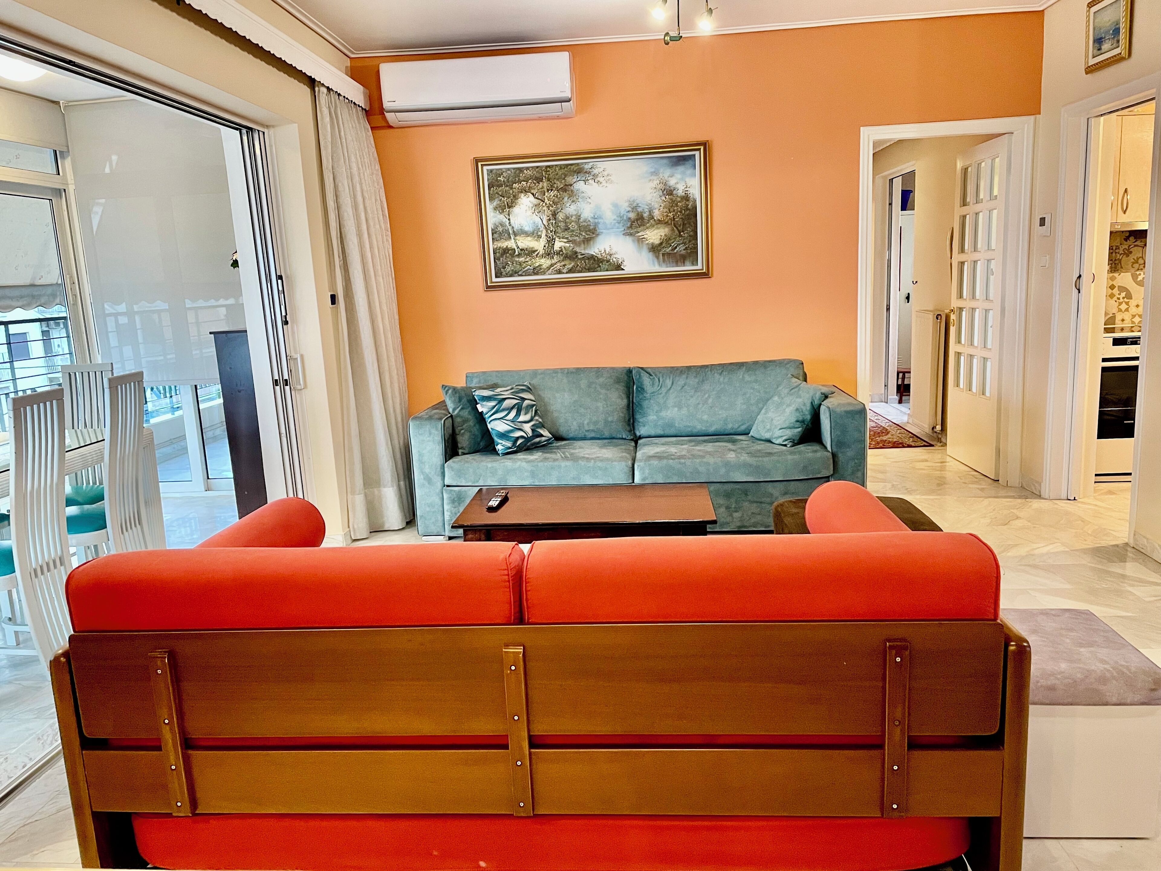 A living room with a sofa, a coffee table, and a painting on the wall.