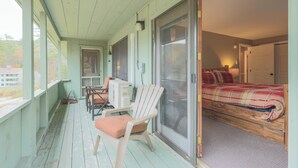 A room with a bed, a chair, a desk, and a sliding glass door leading to another room. - Official Seasons RMC Condo 11G - 2 bedrooms + loft - sleeps 10 - No Fees (Bartlett)