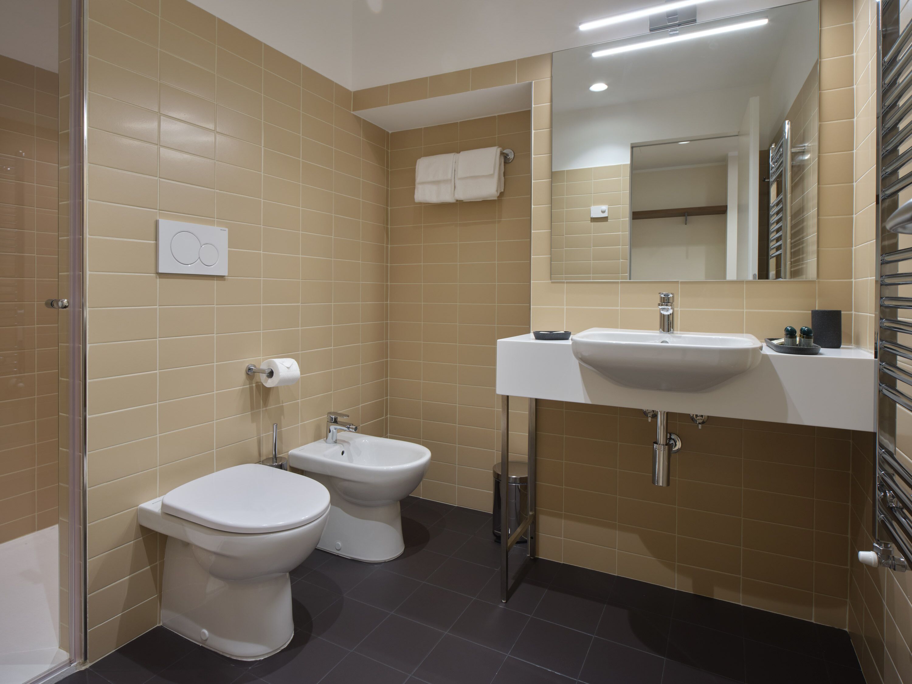 A modern bathroom with a toilet, bidet, and sink.