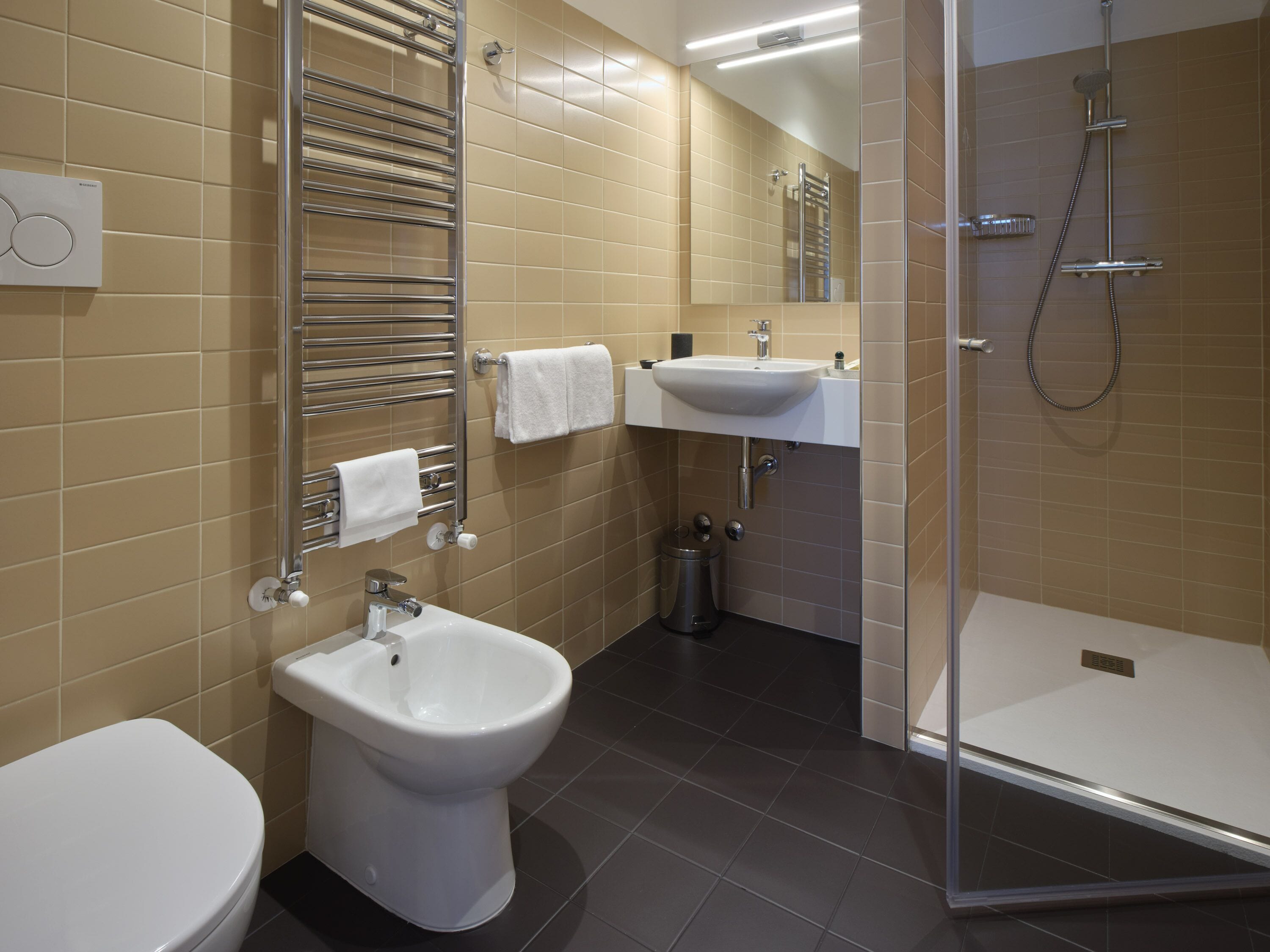 Ein modernes Badezimmer mit Toilette, Bidet und Dusche.