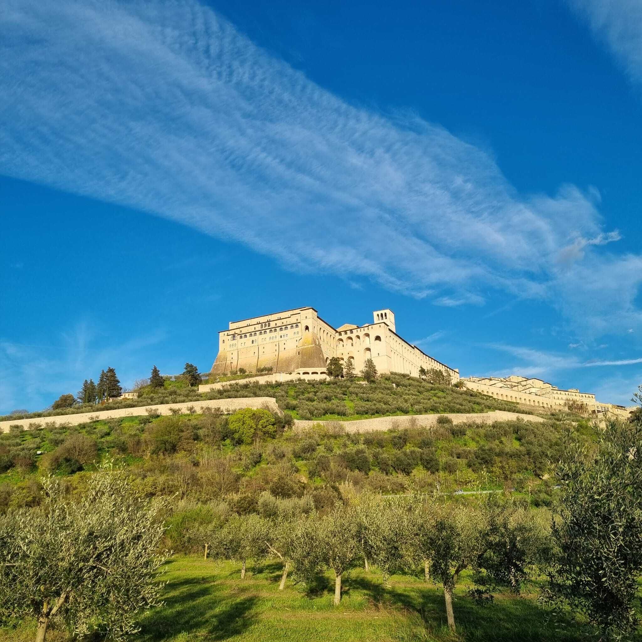 Un vaste château fortifié, perché sur une colline, sous un ciel dégagé.