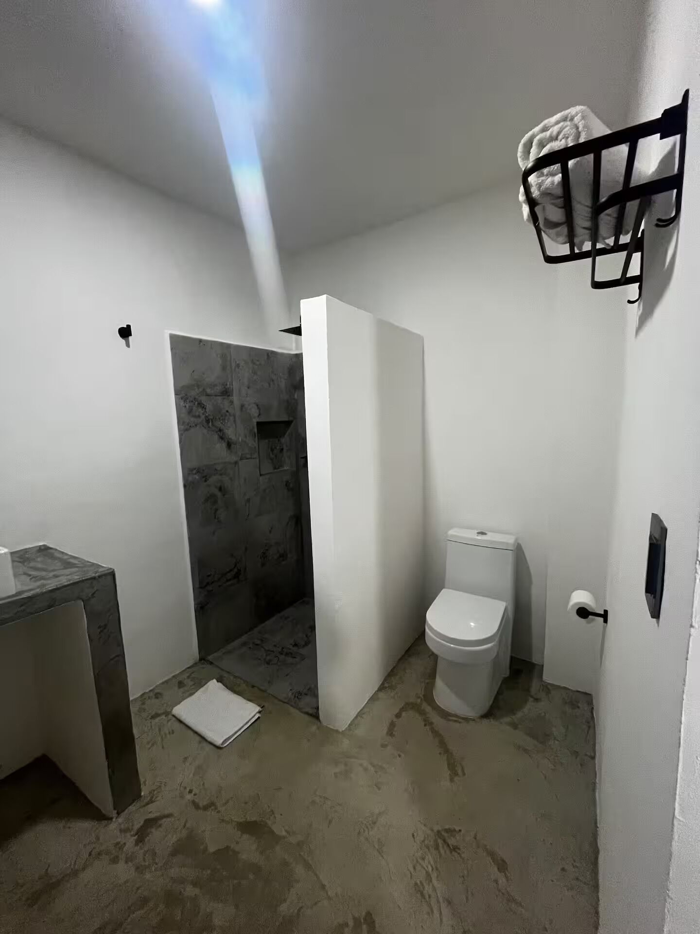 A bathroom with a shower, toilet, and sink.