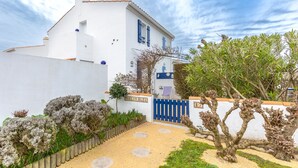 Un edificio blanco con puerta azul y un letrero que dice 'MARLIN BLEU'.