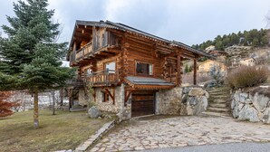 A wooden log cabin with a stone foundation, a balcony, and a stone staircase leading to the entrance. - Chalet des Sonnailles - Montagnes, jardin et garage (Bolquère)
