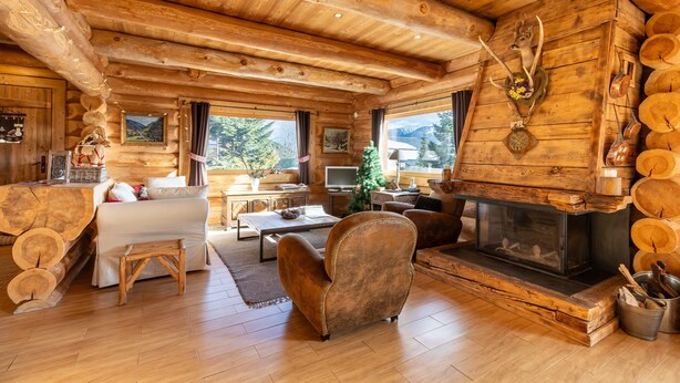 A log cabin interior with a fireplace, wooden furniture, and a cozy seating area. - Chalet des Sonnailles - Montagnes, jardin et garage (Bolquère)